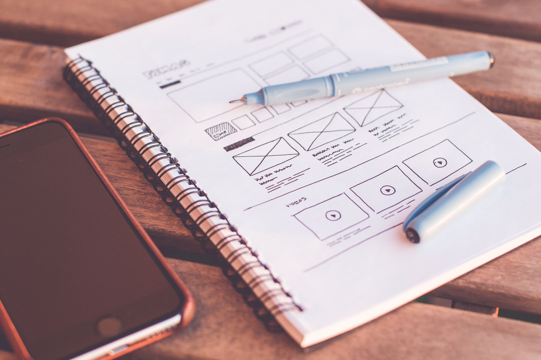 Hand sketching a mobile app wireframe on a whiteboard with a marker